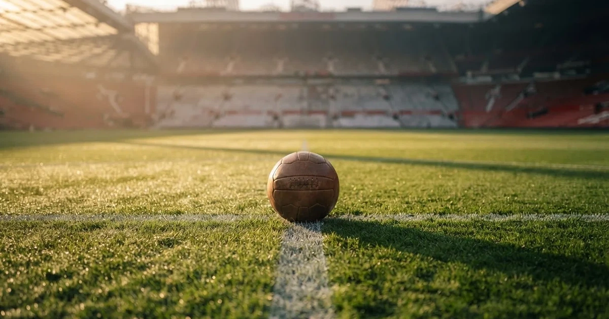 A ball on the centre spot of a grass pitch in morning light