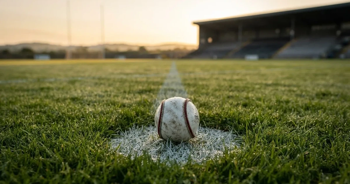 A ball on the centre spot of a grass pitch in morning light