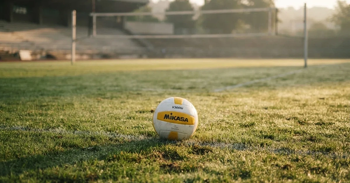 A ball on the centre spot of a grass pitch in morning light